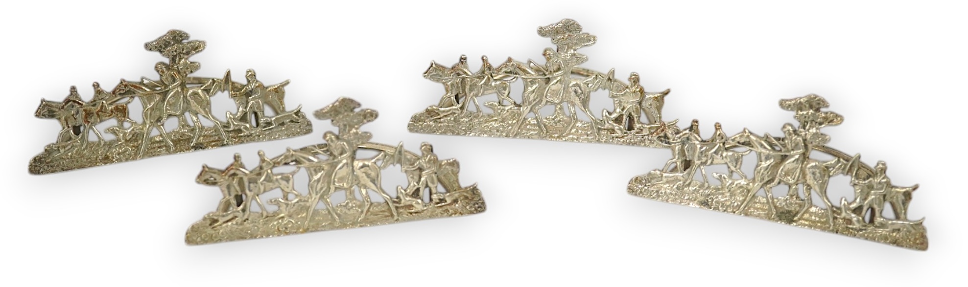 A set of four Edwardian pierced silver 'hunting scene' menu holders, by Stuart Clifford